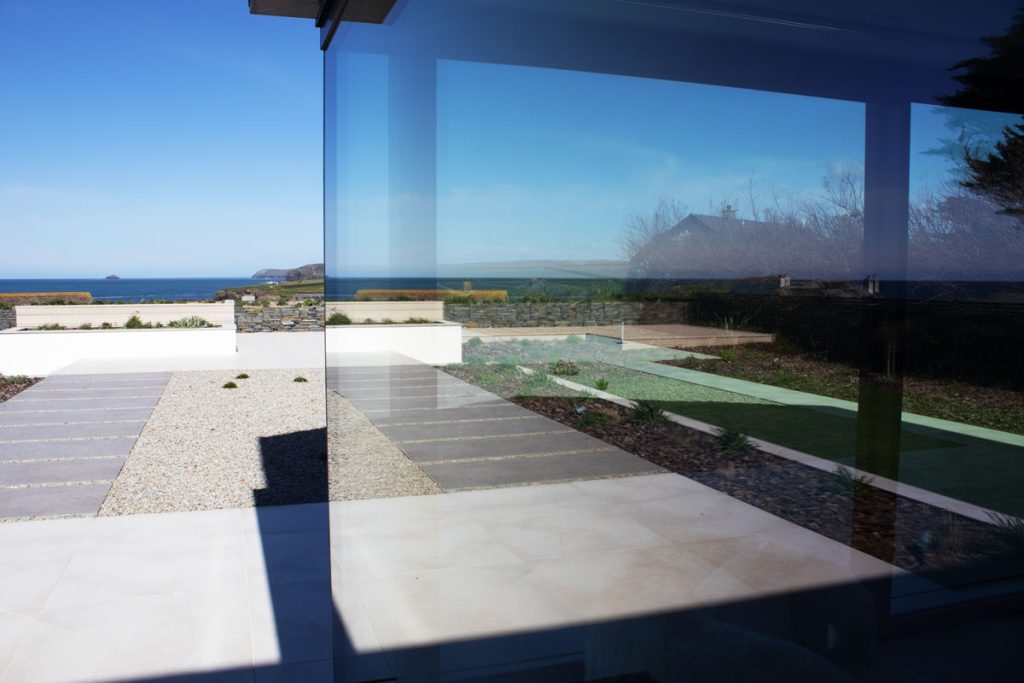 Floor-to-ceiling architectural glazing offering expansive sea views from a modern home